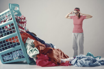 Disappointed angry woman looking at dirty clothes - obrazy, fototapety, plakaty