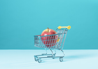 Fresh apple in a tiny supermarket trolley