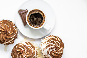 Black coffee with cupcakes and muffins. Spice cupcakes with creamcheese frosting decorated with a cocoa