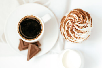 Dark chocolate and cocoa chocolate cupcakes with a cup of hot black coffee on green napkin. Space for text