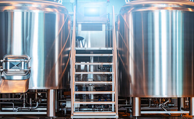 Modern beer factory, brewery concept. Steel tanks and pipes for beer production. Industrial...