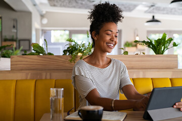 Young african woman using digital tablet at coffee shop