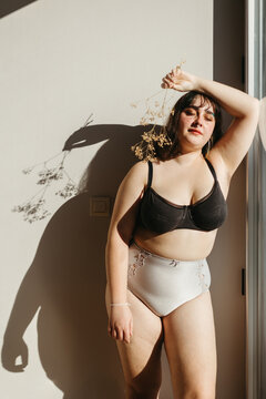 Overweight woman in underwear with dried flowers