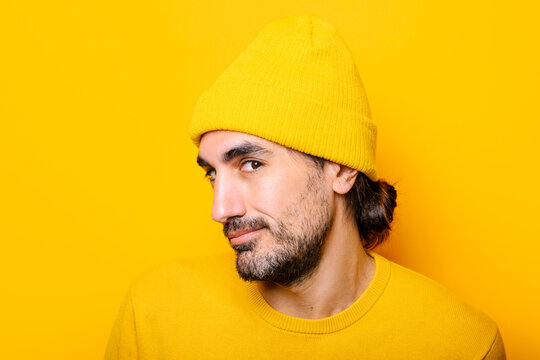 Cheerful man looking at camera in yellow studio