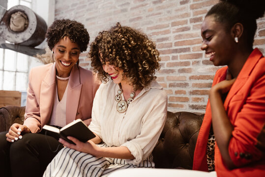 Positive multiethnic colleagues writing on notepad