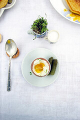 spring breakfast in white colors. Soft boiled egg and pickled cucumbers