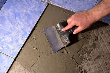 Close-up of the man's hands, in one of which he sees a spatula, with which he applies the solution...