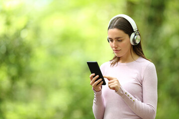 Woman listening to music in a green background