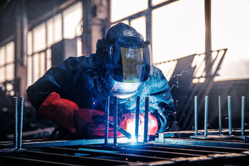Factory industry worker welder in protective uniform with mask on workplace metalwork