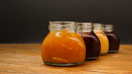 Home-made jam, selective focus. Jars with marmalade, confiture. Sweet dessert for toast, pie. Breakfast preparation.