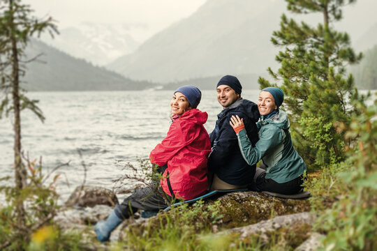 A group of friends enjoy a stunning view of an idyllic mountain lake in a nature park in the Nordic country