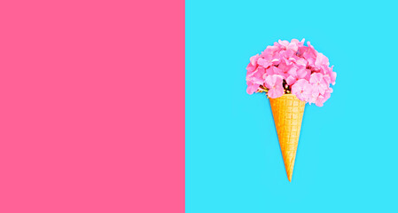 Cone ice cream with colorful flowers on blue background, blank copy space for advertising text