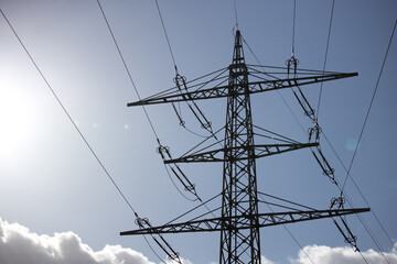 a high voltage pylon in front of a sunny sky