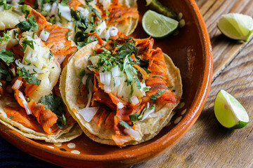 Mexican tacos al pastor accompanied by vegetables and sauces