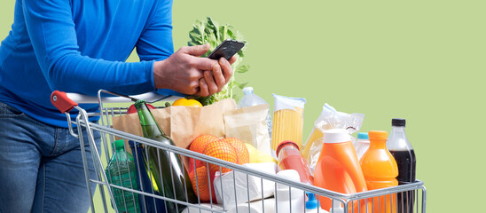 Man doing grocery shopping and connecting with his smartphone