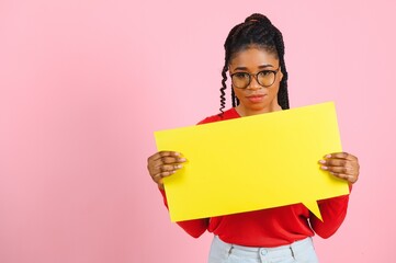 Place For Text. Happy black woman pointing at white advertisement board isolated over pink wall, copyspace