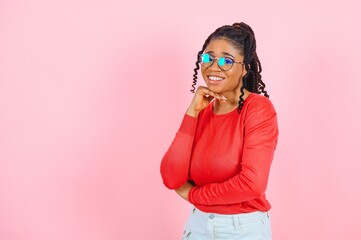 Studio shot of glad charming young female with Afro haircut, isolated over pink background with blank space for your promotional content. Pleasant emotions