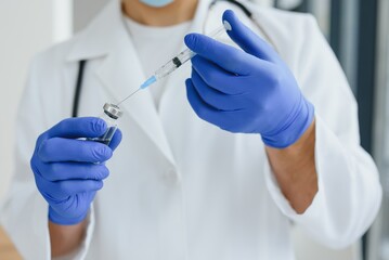 Doctor, scientist, researcher hand in blue gloves holding flu, measles, coronavirus, covid-19 vaccine disease preparing for human clinical trials vaccination shot, medicine and drug concept.