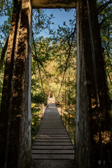Obraz premium Old wooden suspended bridge above a calm river in Galicia, Spain