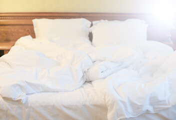 Bedroom bed in hotel room or apartment. Morning mess, bed linen
