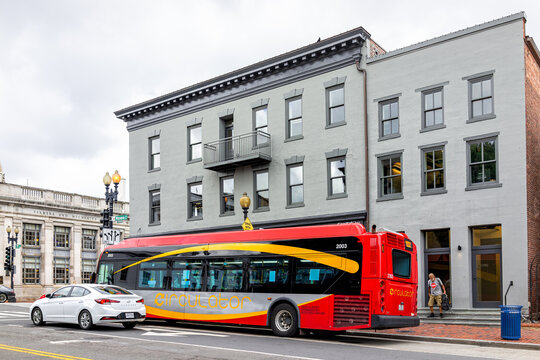 Washington DC, USA - August 18, 2021: Georgetown M Street With Buildings In University Neighborhood And Red Circulator Bus In Traffic Public Transportation