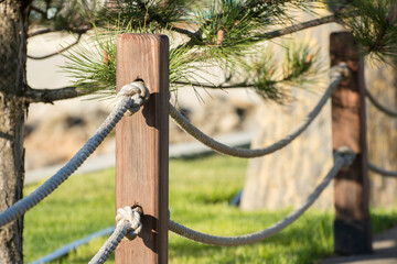Handmade fence from hemp ropes in public park.