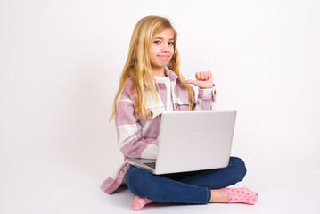 Closeup of cheerful caucasian teen girl sitting with laptop in lotus position on white background...