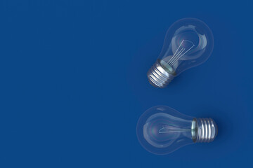 Two light bulbs on blue background. Top view. Copy space. 3d render