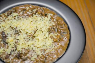 Tasty funghi risotto with meat and cheese