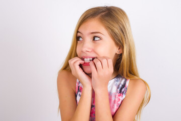 Fototapeta premium Terrified little caucasian kid girl wearing sport clothing over white background looks empty space home alone moonless night