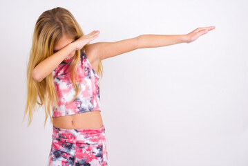 Photo of funky little caucasian kid girl wearing sport clothing over white background show disco...