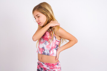 little caucasian kid girl wearing sport clothing over white background got back pain