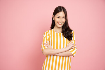 Portrait of Happy Asian woman traveler with arms crossed and smile isolated over pink background © comzeal