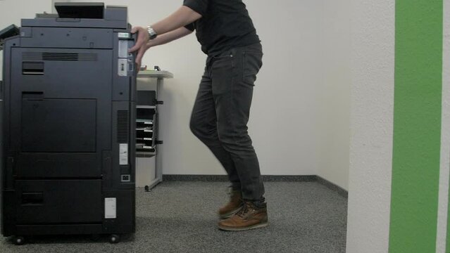 Technician dismantles a multifunction device.