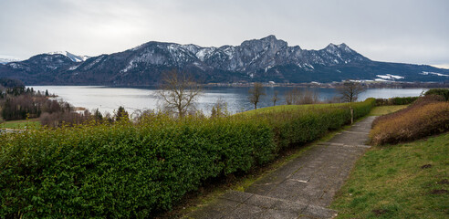 View of Lake Mondsee and the surrounding mountains from sidewalk