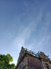  collapsed building seen from below with blue sky in summer