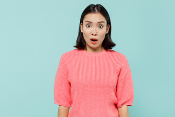 Fototapeta premium Young shocked surprised woman of Asian ethnicity 20s wearing pink sweater look camera with opened mouth isolated on pastel plain light blue color background studio portrait. People lifestyle concept.