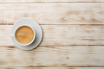 Cup of delicious coffee on wooden background, top view