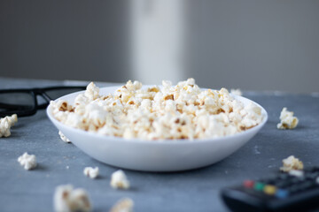 bowl of popcorn, 3D glasses. Still life on blue background. Flat lay, Top view. Concept pastime, entertainment and cinema.