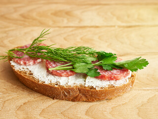 Making sandwiches with bread, cheese, sausage and herbs.