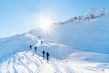 Fototapeta na wymiar Group of alpinist people going on top of moutain with ski gear during a sun day without cloud