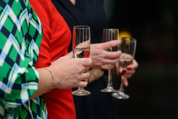 woman wearing a green dress, holding a glass with champagne