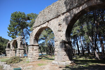 Fototapeta na wymiar ruins of the ancient aqueduct in Phaselis, Turkey with the sea on the background