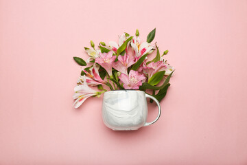 pink flowers in a cup on a pink background. top view 
