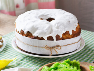 Easter cake with raisins decorated with white icing on a green checkered tablecloth. Festive pastries for a family dinner. Rustic. The concept of traditional food.