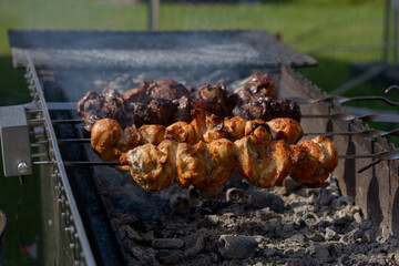 Skewer chicken pieces roasting on the grill and smoke