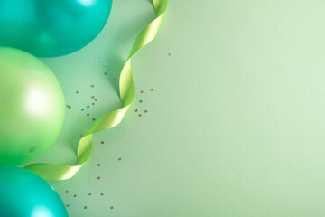 St Patricks Day party background. Balloons and festive decor on pastel green surface. Top view, flat lay, copy space © Elena