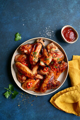 Grilled spicy chicken wings with ketchup . Top view with copy space.