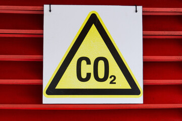 CO2 warning sign on a red background. Yellow triangle security labeled carbon dioxide.