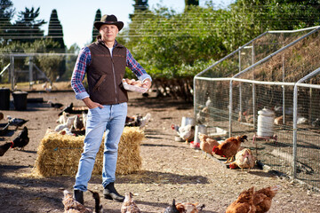 Man holding tray of natural eggs at chicken farm